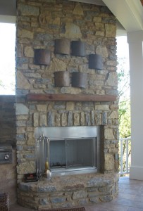 The covered porch off the kitchen features a stone fireplace and built-in grill.
