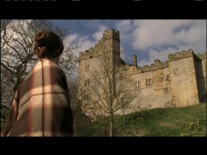 Jane looks up at the roof of Thornfield, where Grace Poole is shaking out the rugs.