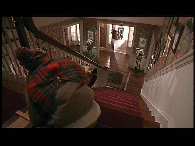Kevin decides to take a sled ride down the stairs.