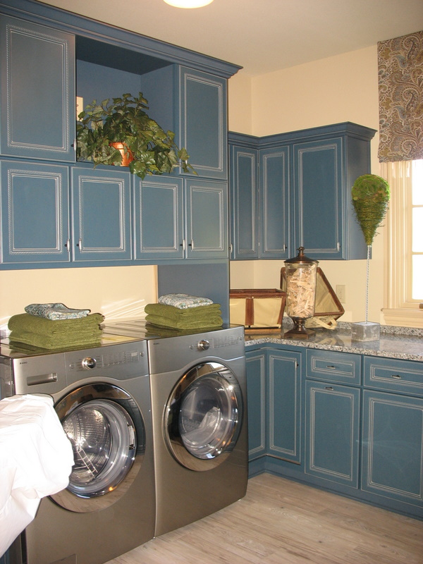 The laundry room with blue cabinets.