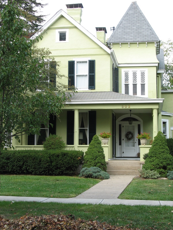 pale green house with porch and shutters