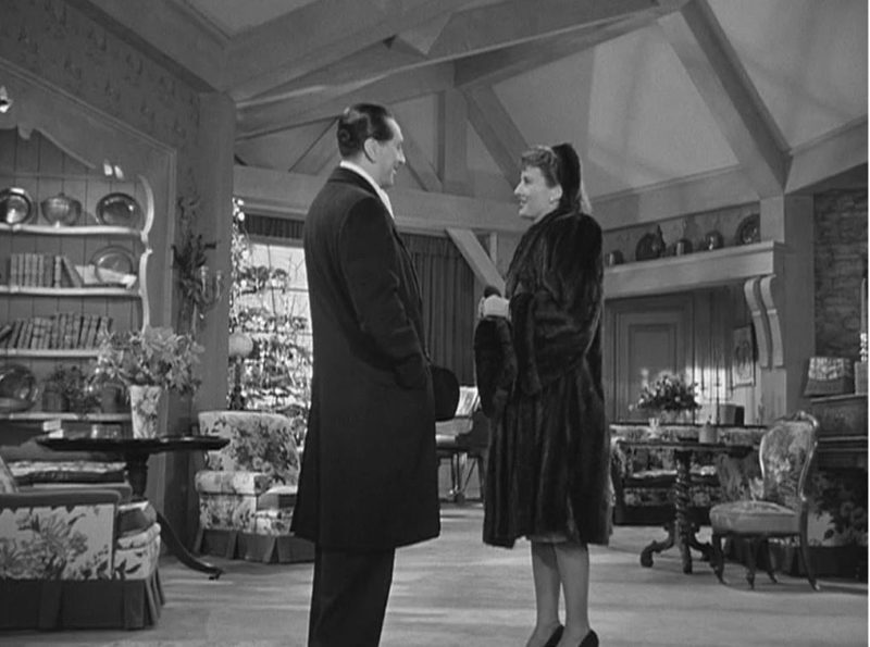 Elizabeth and John talking in the farmhouse living room