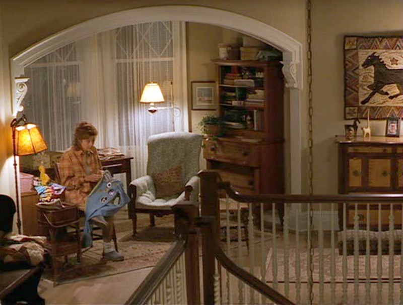 Susan Sarandon sewing in chair in upstairs landing