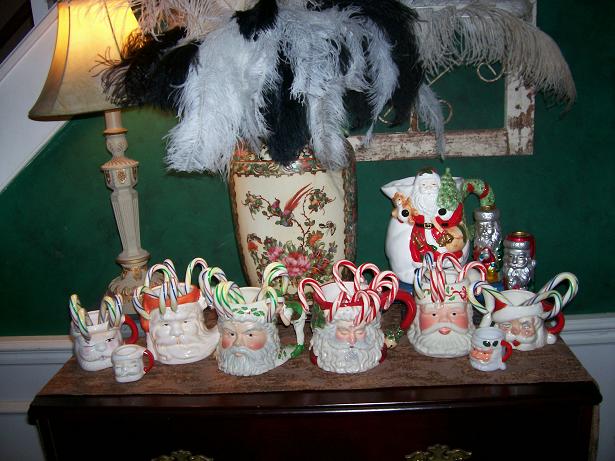 A group of Santa mugs with candy canes in them