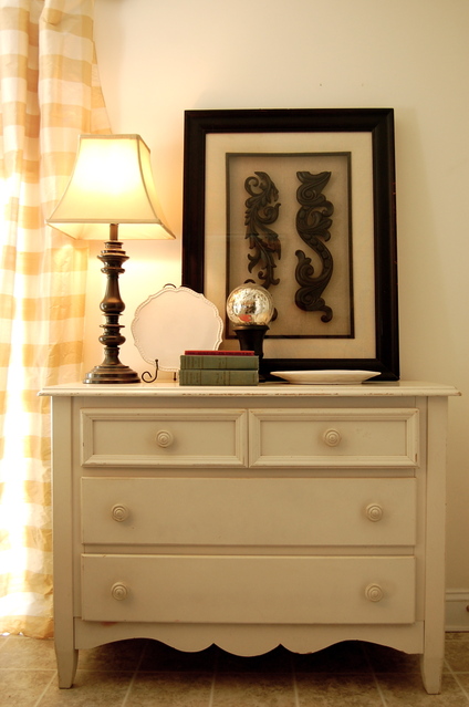 dresser with lamp and artwork