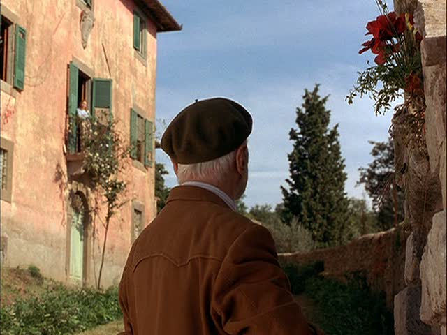 An old man standing in front of the villa