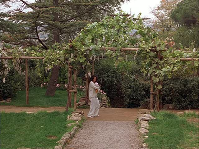 Sandra Oh holding her baby under the pergola