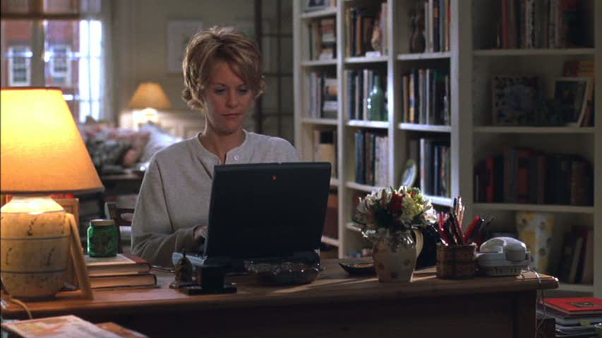 A person sitting at a table in front of a laptop