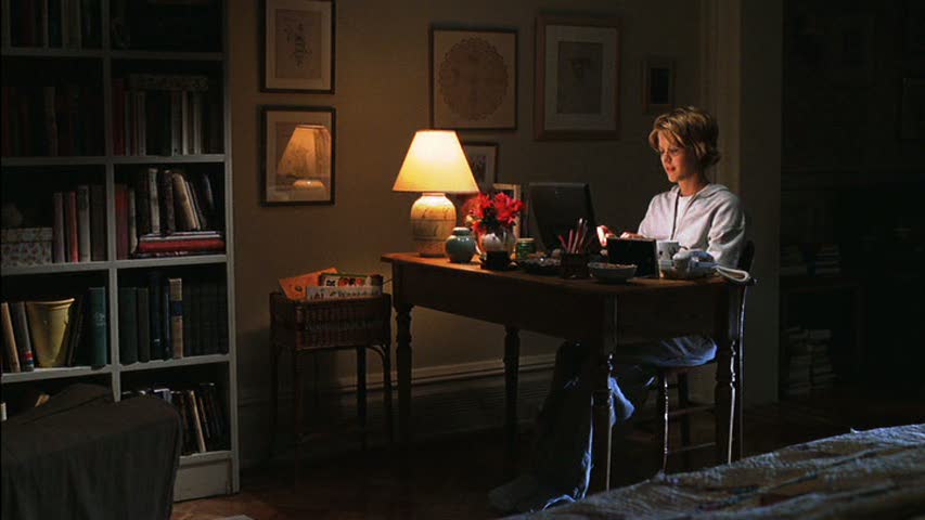 Meg Ryan works on her laptop in her apartment