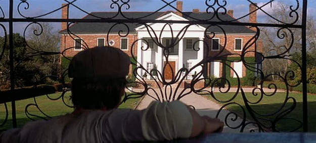 Ryan Gosling looking through iron gates at Boone Hall Plantation house