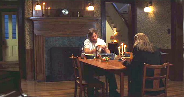 Noah and Allie sitting at the table in the dining room in front of the fireplace