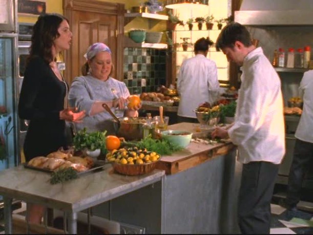 A group of people standing in a kitchen preparing food