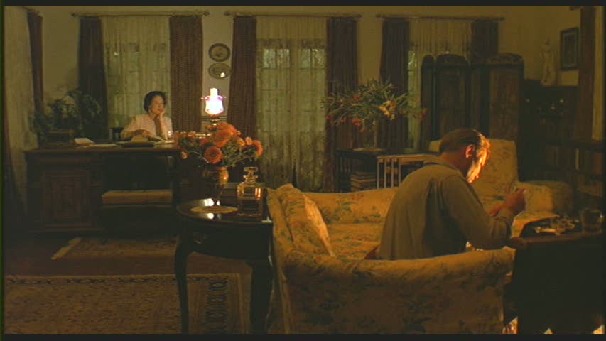 A man and a woman sitting in the living room at night