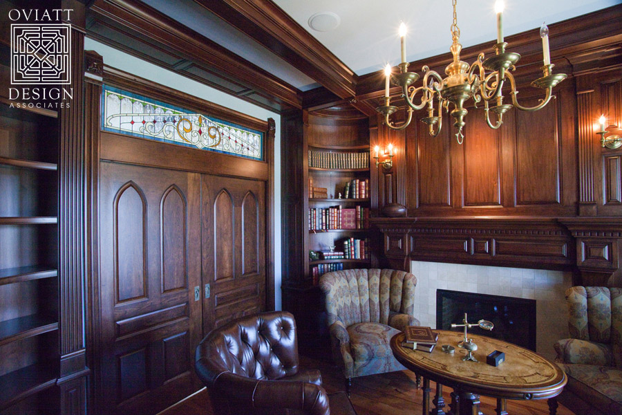 paneled room with fireplace and chandelier