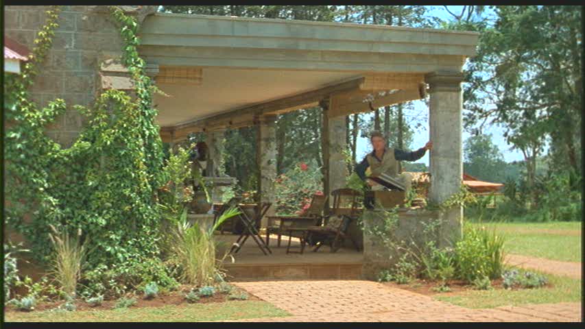 Robert Redford standing on front porch of house