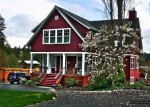 exterior view of red cottage with white trim and front porch on Bainbridge Island