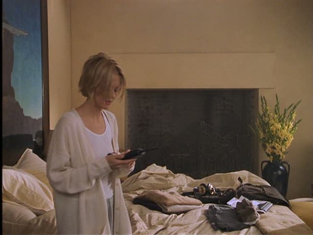 Meg Ryan walks past bed