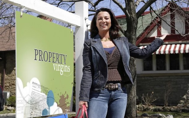 Sandra Rinomato standing in front of a Property Virgins sign