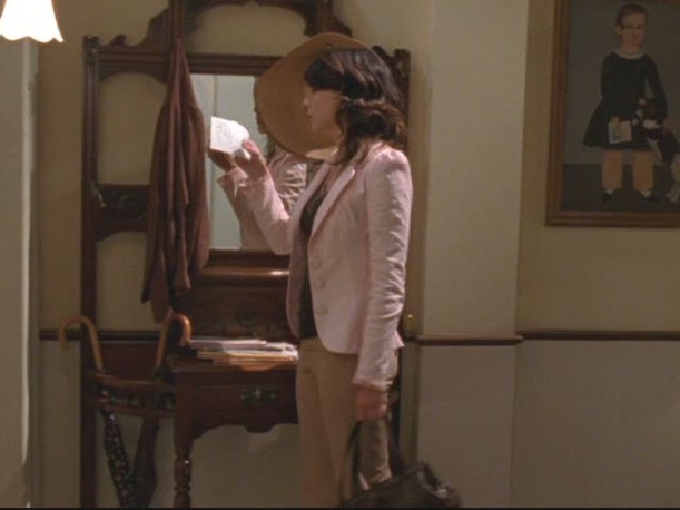 Lorelai standing in entry hall reading a note