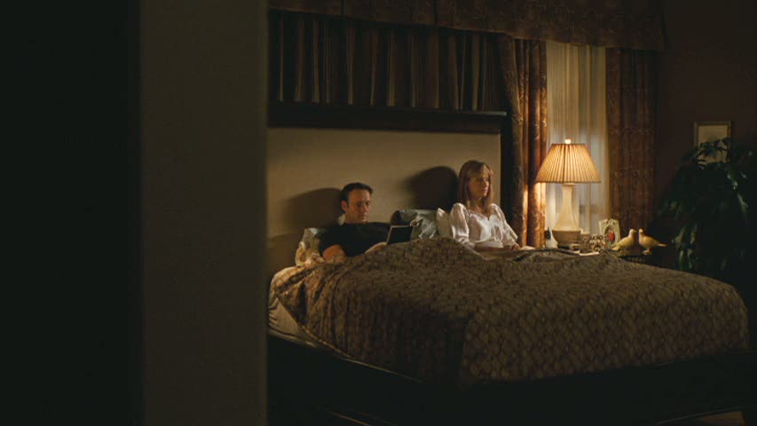 couple sitting up in bed in bedroom