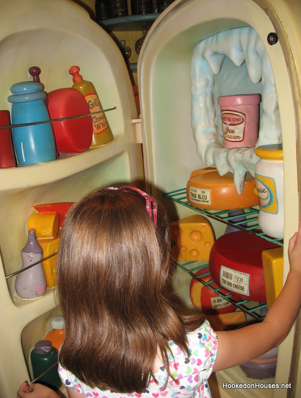 girl looking in Minnie Mouse\'s refrigerator at Disney World