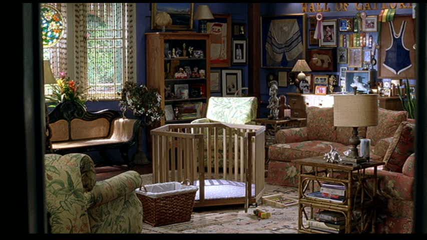 A living room filled with furniture and a play pen