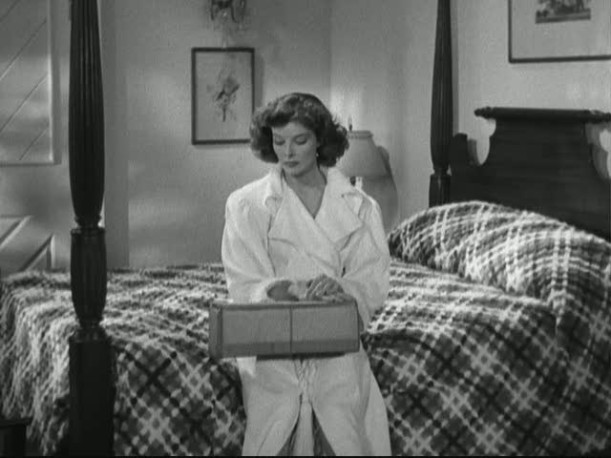 Katharine Hepburn sitting on a bed