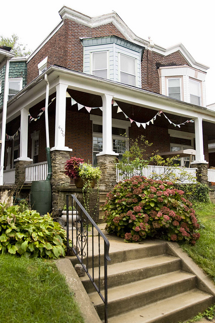 front exterior of two story brick house with porch