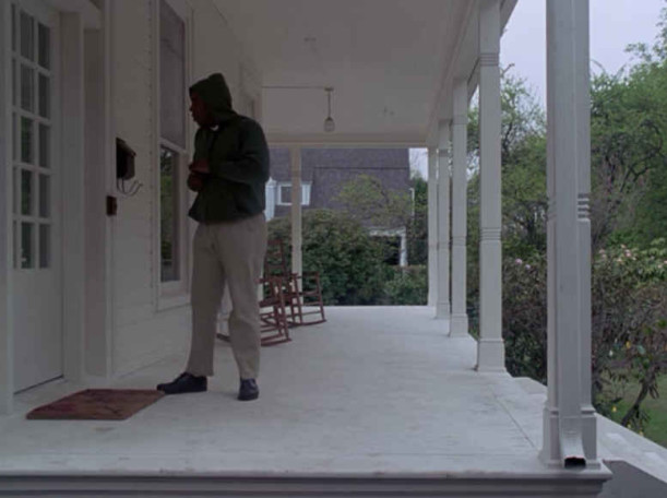 A man standing on front porch 