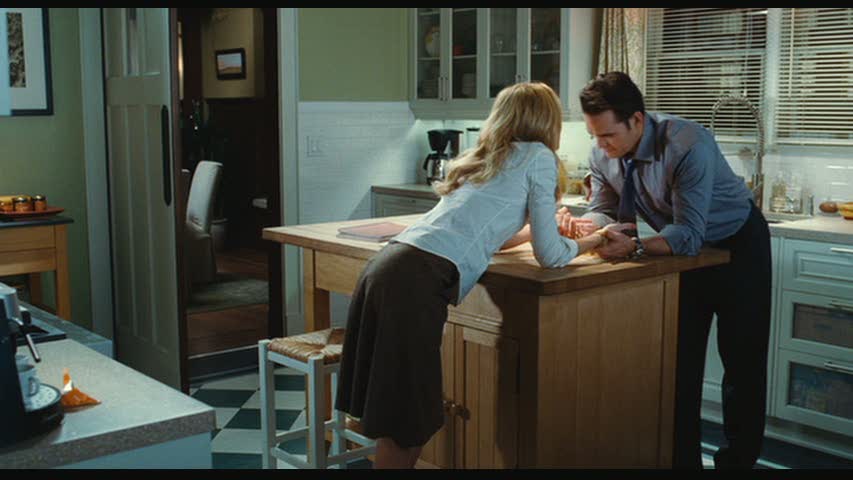 A man and a woman standing over kitchen island