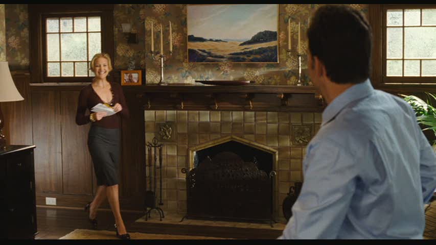 A person standing next to a fireplace, with Kate Hudson