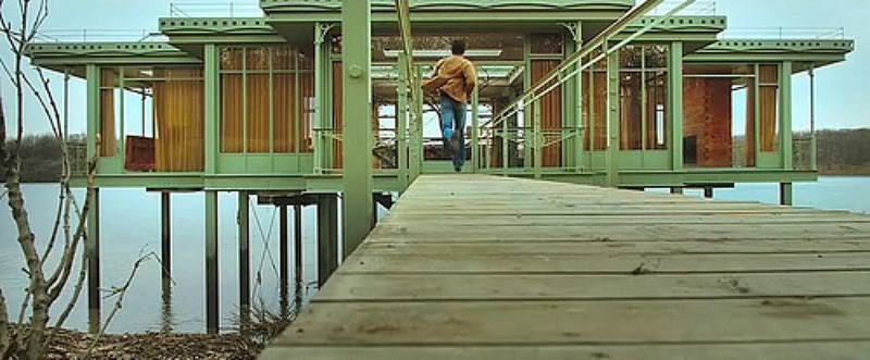 A wooden dock in front of lake house