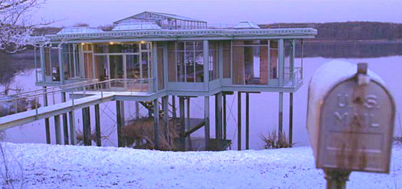 the glass lake house covered in snow