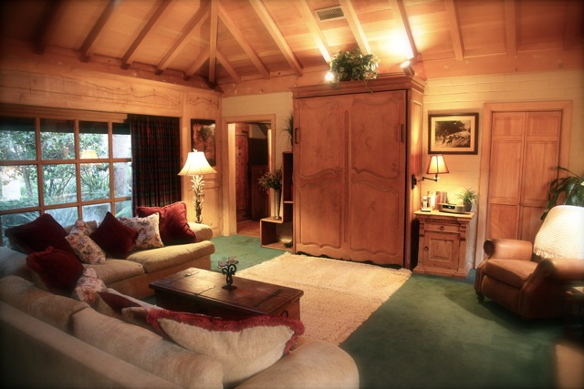 A view of a living room filled with furniture and large TV armoire