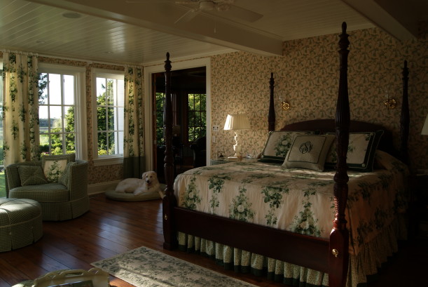 owner\'s bedroom with four poster bed and dog on floor