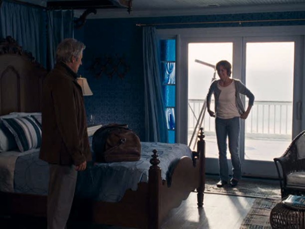 A man and a woman standing in front of a window, with Inn At Rodanthe