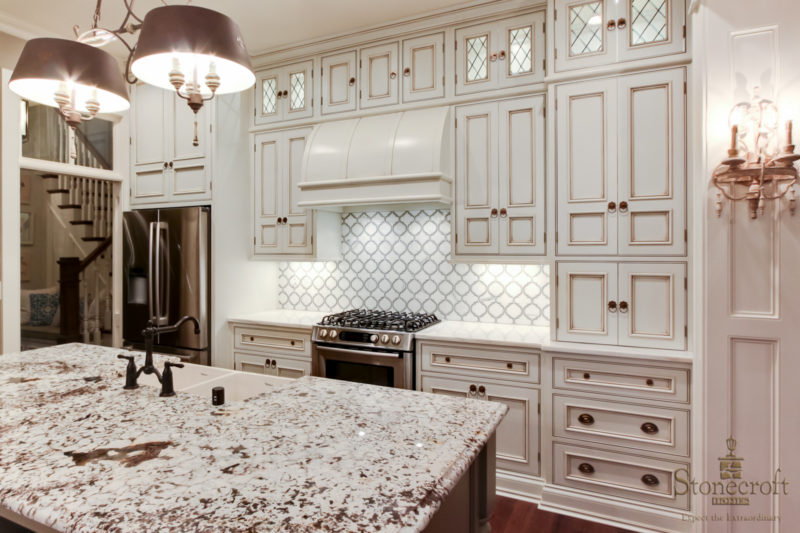 kitchen cabinets and large vent hood over range