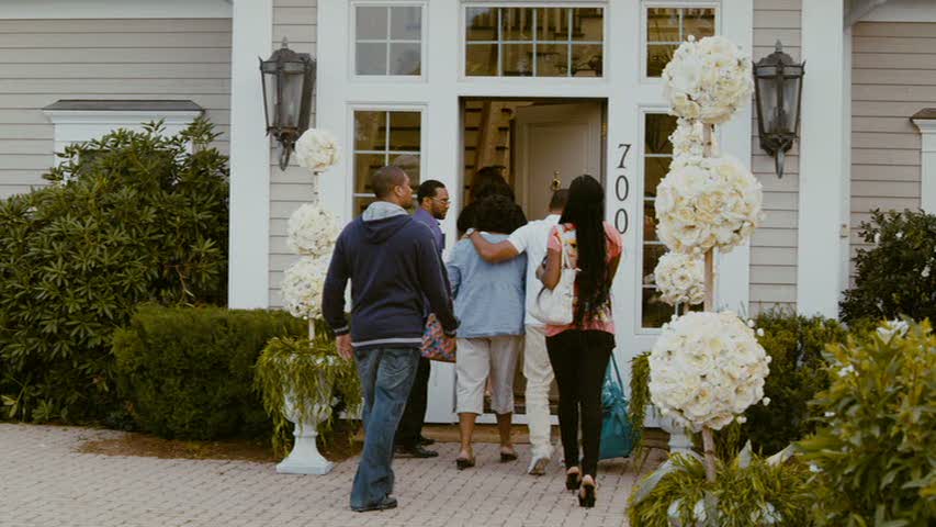 wedding guests walking through the front door of the house