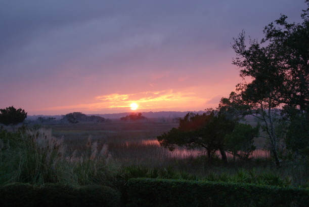 A sunset over a grass field