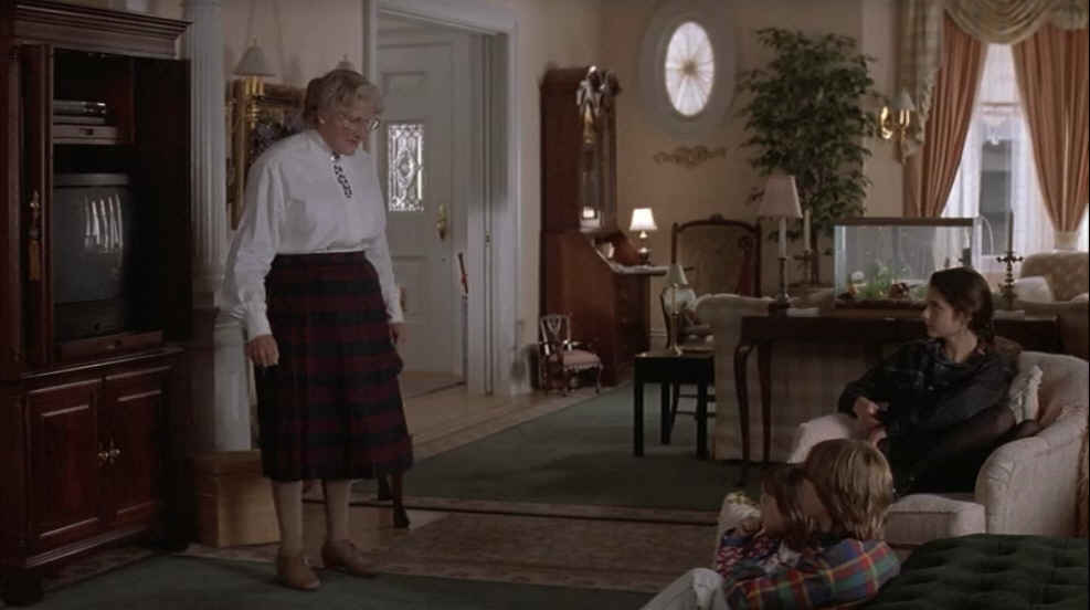 Mrs. Doubtfire standing in living room by TV