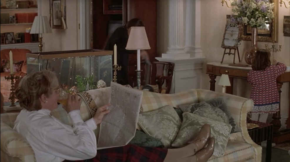 Mrs. Doubtfire reading on living room sofa