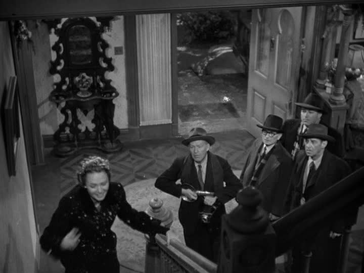 group of men stand at base of staircase in Bailey house