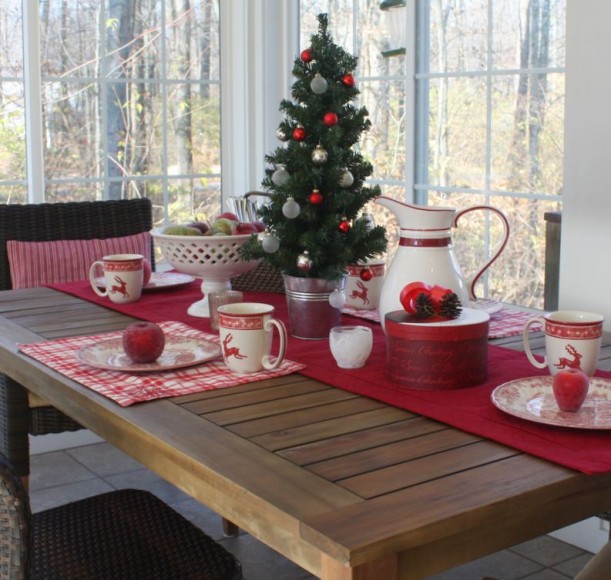 A dining room table in front of a window decorated for Christmas