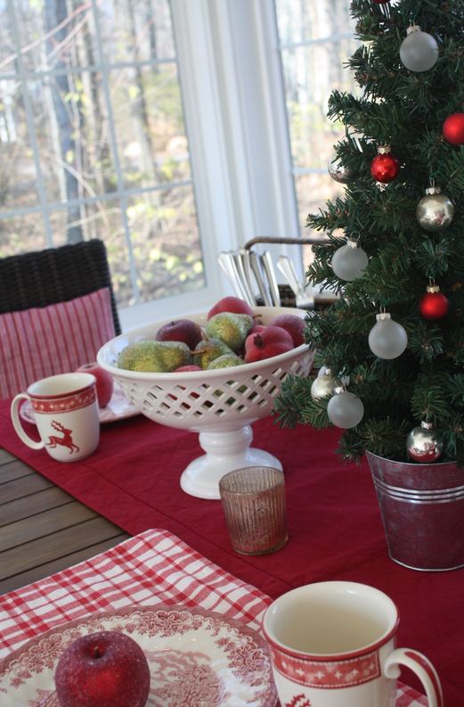 A cup of coffee on a table with small Christmas tree