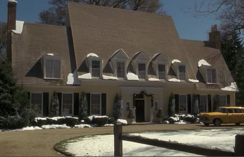 yellow house with dormer windows in the snow in Miracle on 34th Street remake
