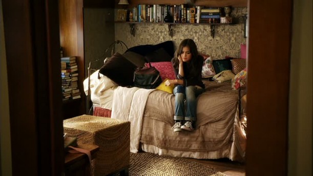 Aria sitting on her bed in her bedroom