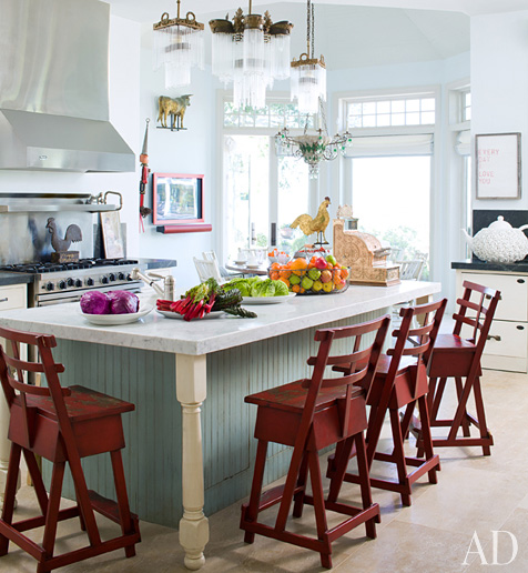 kitchen with pale blue island and red barstools