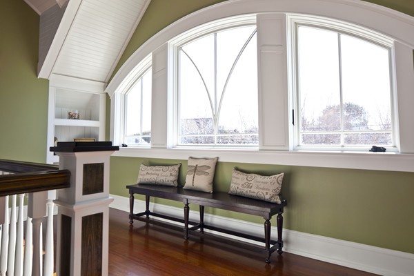 bench underneath large half moon window on stair landing