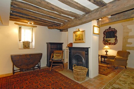 vintage fireplace in room with beamed ceiling