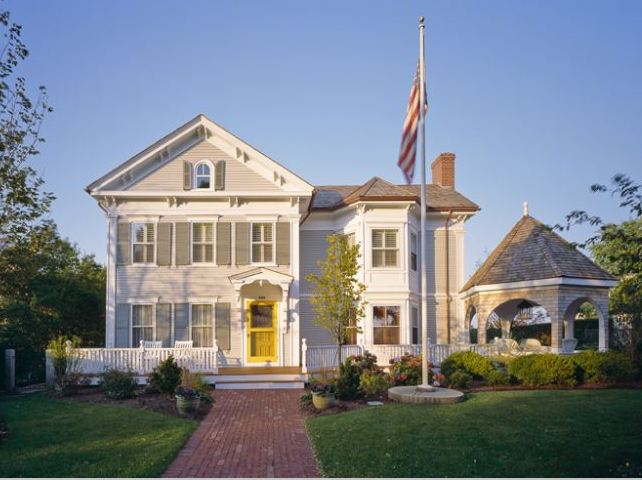 front exterior of an Italianate house in Cape Cod with yellow door